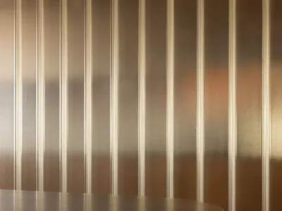 現代餐廳室內，木質餐桌椅搭配金屬條紋牆面。
