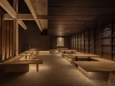 A spacious industrial-style restaurant with wooden tables and seating.
