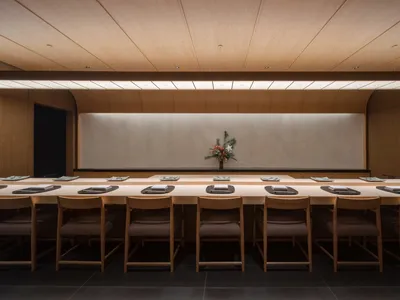 現代簡約餐廳室內，長木桌搭配餐具與花卉中心裝飾。