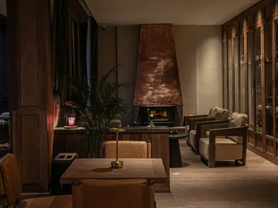 A modern restaurant and bar interior with wooden furniture, glass decor, and a warm, inviting atmosphere.