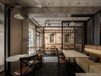 Interior of an industrial-themed restaurant featuring concrete, metal, and wooden elements.