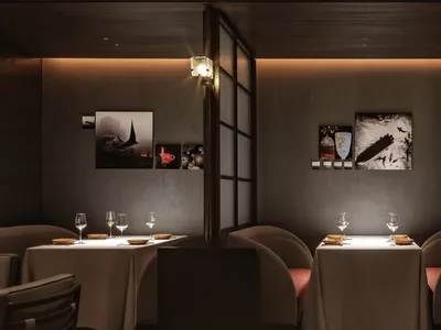 A minimalist restaurant interior with modern design elements and neutral color palette, featuring sleek seating, elegant tabl