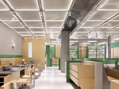 Modern restaurant interior with steel tables, concrete flooring, and wooden accents.