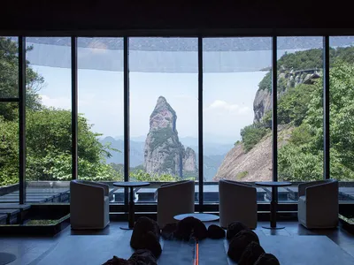 Hotel lobby with glass windows overlooking natural scenery and mountains