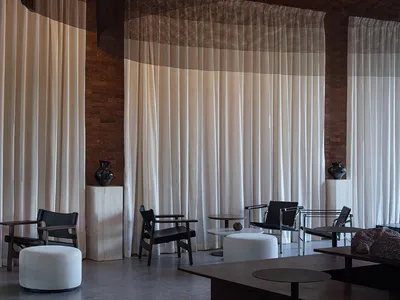 Modern hotel lounge area with soft textiles and concrete elements