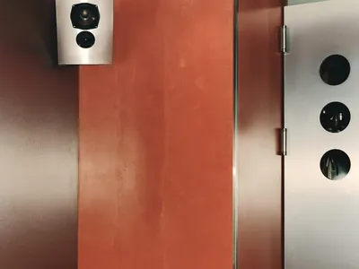 餐廳卡座配有橘色皮革座椅與金屬音響系統。