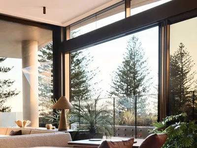 Modern lounge area with wooden furniture, concrete walls, and leather cushions in a restaurant setting.