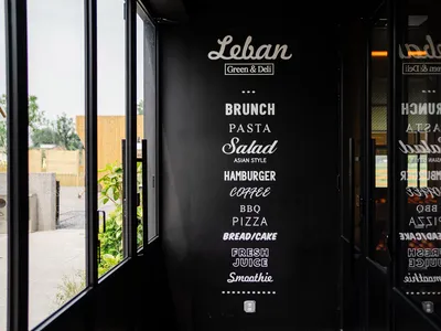 A black menu board featuring a list of food items in white text, including brunch, pasta, salad, hamburger, coffee, BBQ, pizz