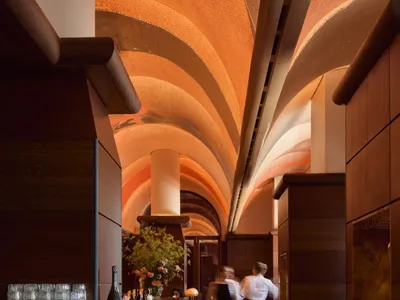Industrial-themed restaurant bar interior with wood laminate flooring and a high ceiling arches