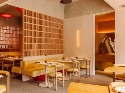 Modern minimalist restaurant interior with sleek, yellow furniture, and contemporary design features.