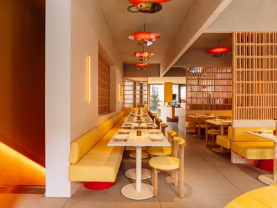 A modern restaurant interior with yellow leather seating and minimalist design.