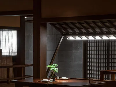 餐廳室內照片，展示木質餐桌椅，中央擺放盆栽盆景，帶有傳統日式元素