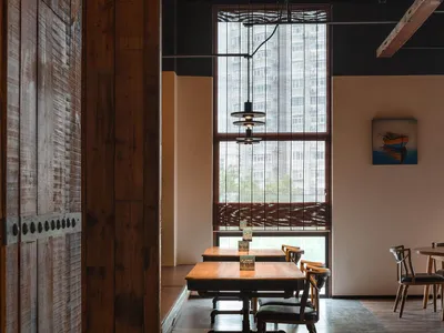 Industrial-style restaurant interior with wooden tables and chairs.