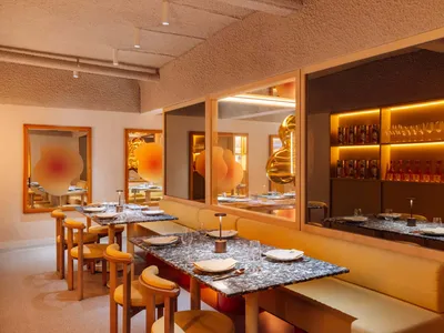 A modern restaurant interior featuring marble, concrete, and cork materials.