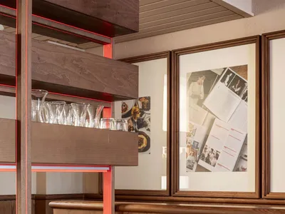 A modern restaurant booth with wooden seating and a marble divider.