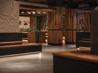 A modern restaurant interior with wooden and concrete elements.