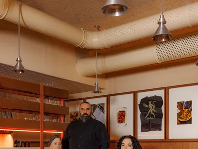 A modern restaurant interior featuring wooden furniture and wall decorations.