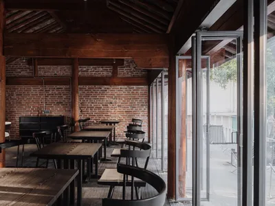 Industrial-themed restaurant featuring exposed brick walls and wooden furniture.