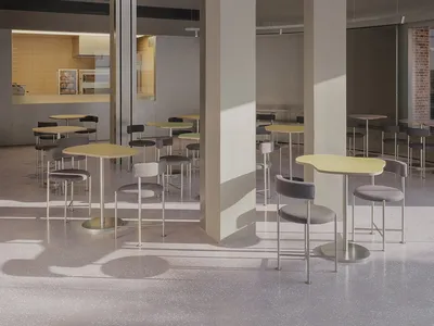 A spacious, industrial-style restaurant interior featuring concrete flooring, high ceilings, and modern lighting fixtures.