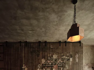 A cozy restaurant interior with rustic wooden walls, a fire pit, and traditional Chinese painting