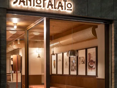 Modern coffee shop interior with wooden elements and framed art hanging on the wall.