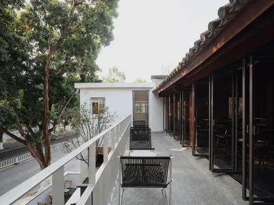 A modern restaurant terrace featuring concrete flooring and a minimalist design.