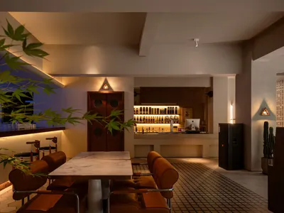 A modern restaurant bar interior with concrete flooring and seating.