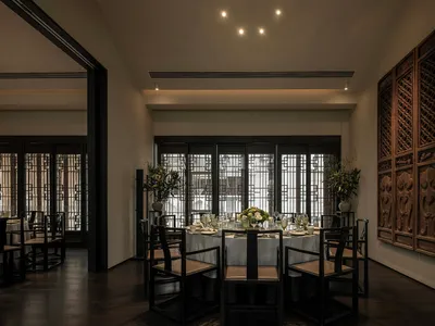 A modern restaurant interior featuring wooden furniture, glass walls, and metal accents.