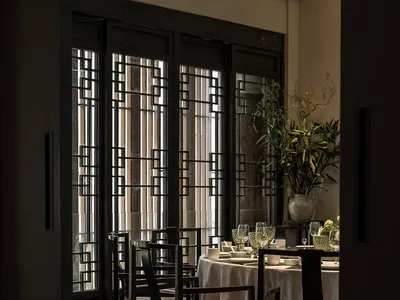 Industrial-style restaurant interior with metal frame chairs and tables.
