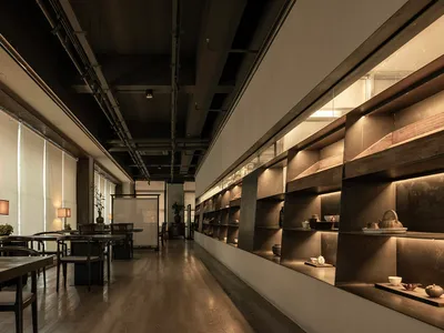 現代餐廳室內長景，木質餐桌椅與混凝土牆面。