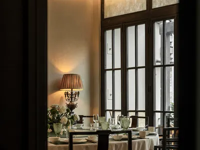 A well-lit, minimalist dining room with clear glass windows and modern furniture.