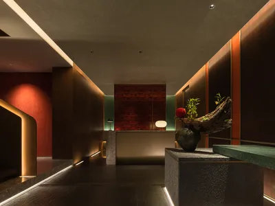 A modern interior design of a hotel front desk reception area featuring concrete and wood materials.