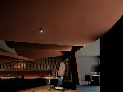 A modern restaurant interior with brick walls and black furniture.