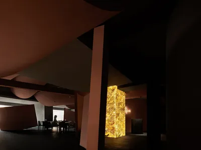A modern restaurant interior showcasing sleek marble surfaces and polished concrete walls.
