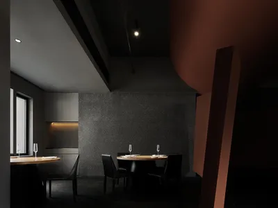 A modern restaurant interior with black concrete walls and metal accents