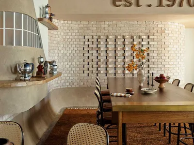 Interior of an industrial-themed restaurant with concrete walls, brick accents, and wooden furniture.