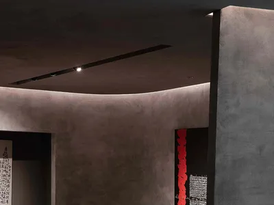 Modernist restaurant dining room with concrete walls, minimalist design, and dining table.