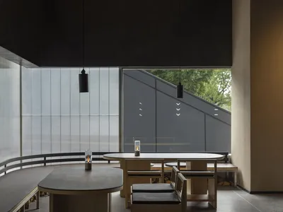 現代餐廳室內空間，搭配木質餐桌與混凝土地板。