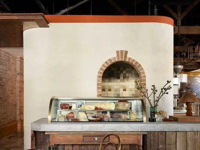 Industrial restaurant interior with concrete, brick, and wooden materials.