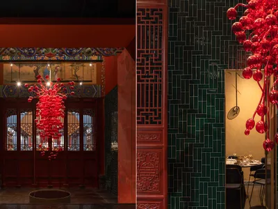 A modern restaurant interior with green tiles and red decorative elements.