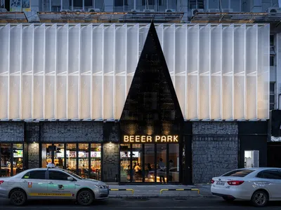Modern restaurant exterior with metal composite paneling and concrete.