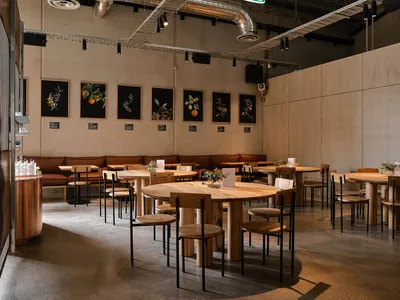 Industrial-themed restaurant interior with wooden tables and chairs