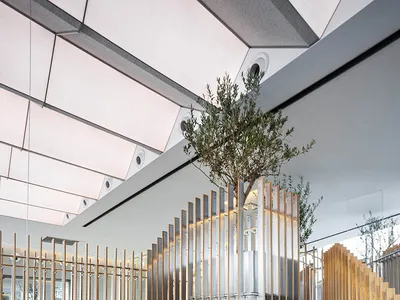 A modern restaurant interior featuring wooden tables, metal accents, and glass elements.