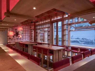 A modern cafe interior featuring wooden furniture and a flowery background