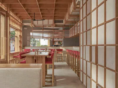 現代餐廳內部，配有木質餐桌與白色牆面。