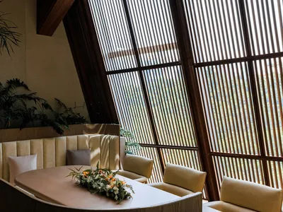 現代餐廳室內空間，配有木質家具與大型窗戶及百葉簾。