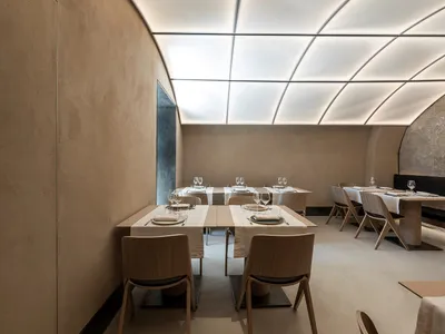極簡餐廳內有木製餐桌與混凝土牆面