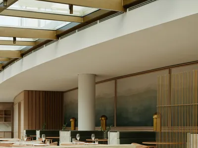 A modern restaurant interior featuring minimalist design elements, with wooden chairs, fabric seating, and glass coffee table