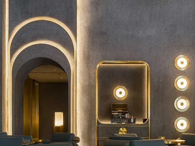 Interior design of a restaurant with industrial-style arches and brass accents.