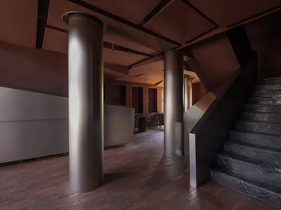 Modern hotel lobby with metallic columns and marble staircase